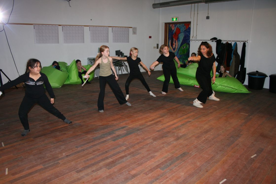 4 meisjes en 1 vrouw die samen dansen met wii controller in hand